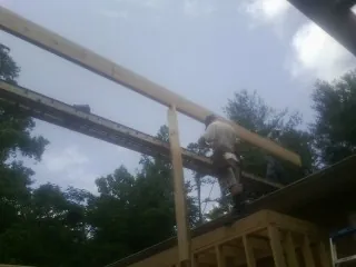 Carpenter setting a ridge beam over a new addition frame — Ice Dam Removal by Roofing Brothers in Osawatomie