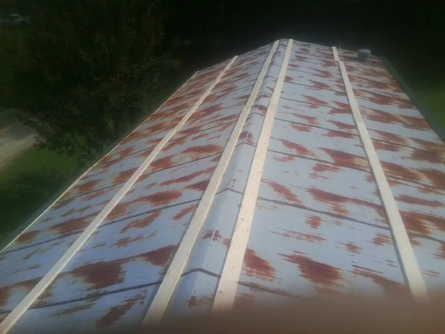 Rusted metal roof panels with new wood purlins before replacement — Storm Damage Roof Repair in Osawatomie by Roofing Brothers