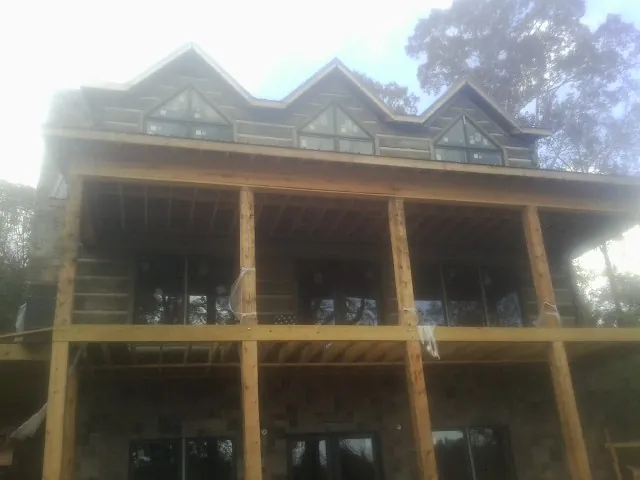 Dormers and porch framing on a large log home under construction — Roof Coating work by our crew in Osawatomie