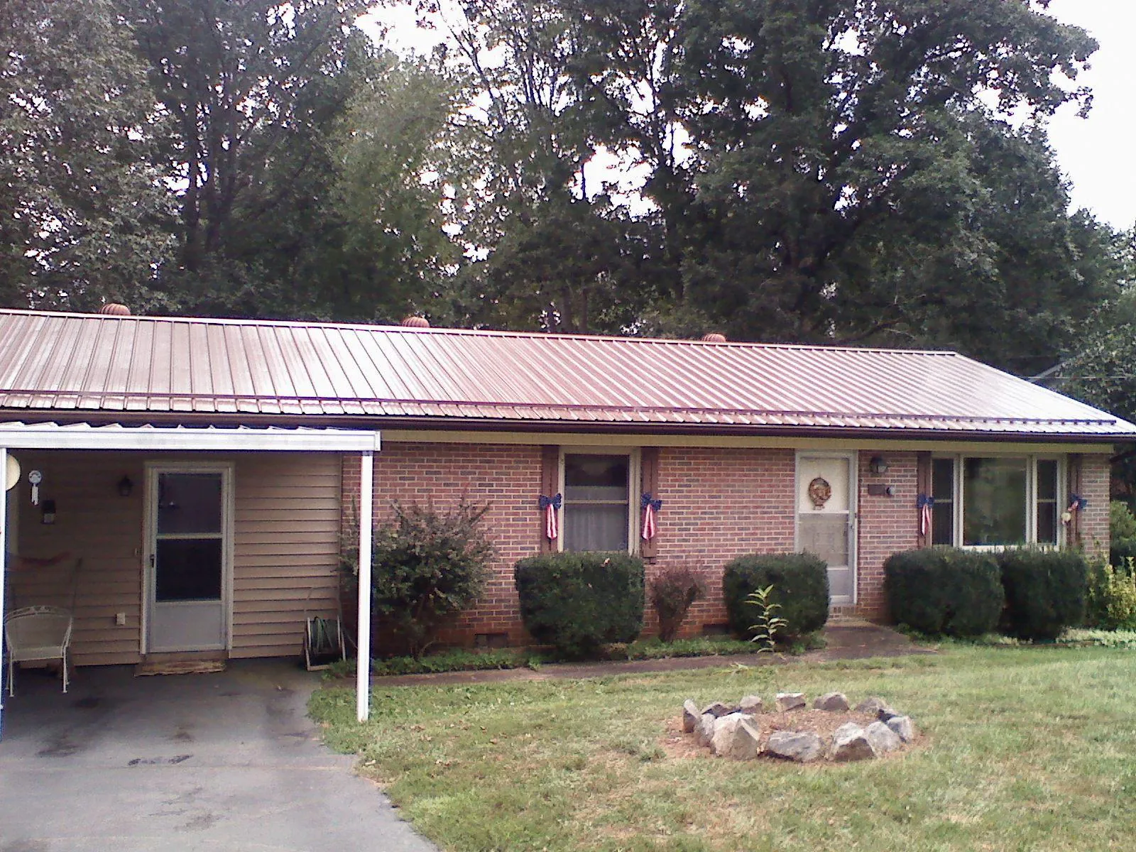 Bronze metal roof and carport on a brick ranch home — Roof Repair work by our crew in Osawatomie