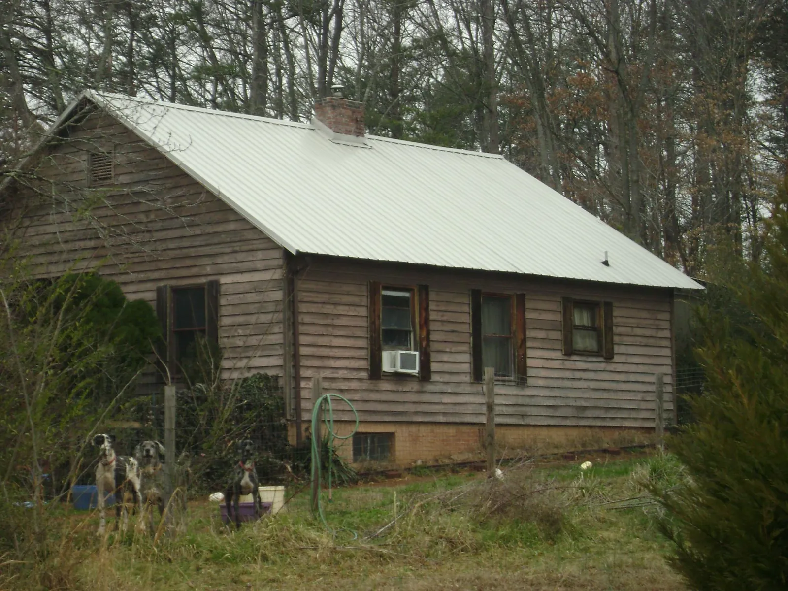 White metal roof on an old wood sided farmhouse, from a Metal Roof Installation job in Osawatomie